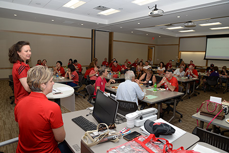 Sue Vagts and Heather Clemens present to actuarial science alumni before a Nebraska football game. 