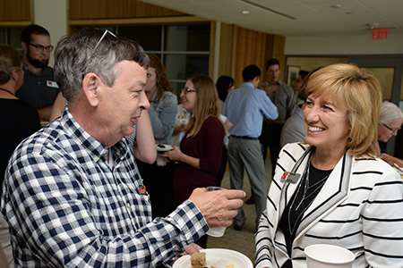 Dr. Matt Cushing, professor of economics, talks with Farrell at one of her Kathy's Point social hours in Howard L. Hawks Hall.