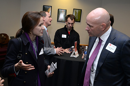 Matt Marsh (right) and the other panelists talk to students at the networking reception following the panel.