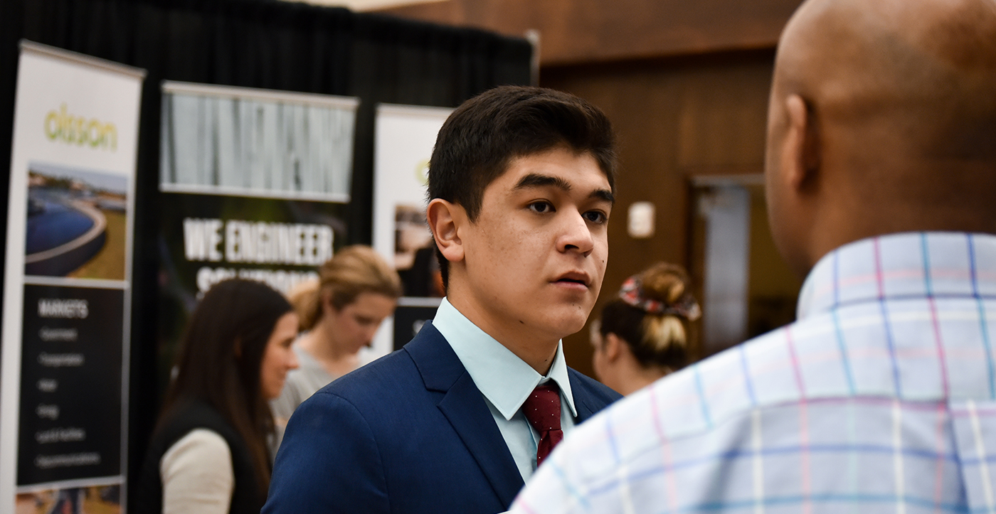 Student connecting with an employer at a career fair.