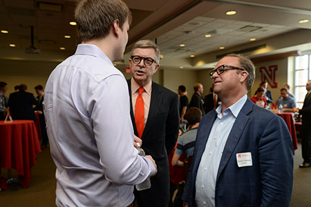 Tom Henning and Michael Johnson speak to a business student.  