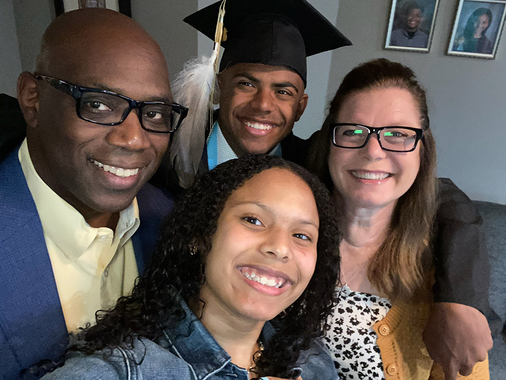 Branch poses with his parents, Troy, ’93 & ‘97, and Julie, '94, ’00 & ’09, and sister, Kya, for his high school graduation, where he wore an eagle feather on his mortarboard, a tradition in many Native communities that honors a significant life accomplishment.