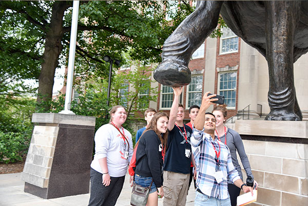 Fares Afshoonkar takes a selfie of Discover Accounting students. Seth Sherwood, center, touches the bottom of the Archie's foot for good luck at Morrill Hall.