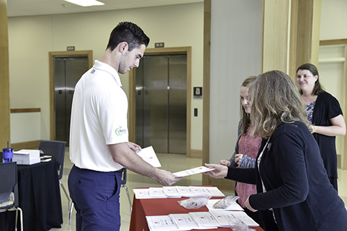 Taylor Gannon, a finance and economics major from Grand Island, Nebraska, receives the Hicks Scholar from members of the business advising and student engagement team.
