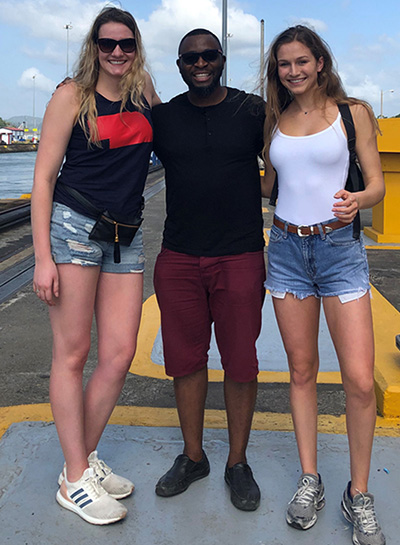 Maggie Schlecht, Dr. Kalu Osiri and Leigh Hanson stand on the Miraflores Lock of the Panama Canal.