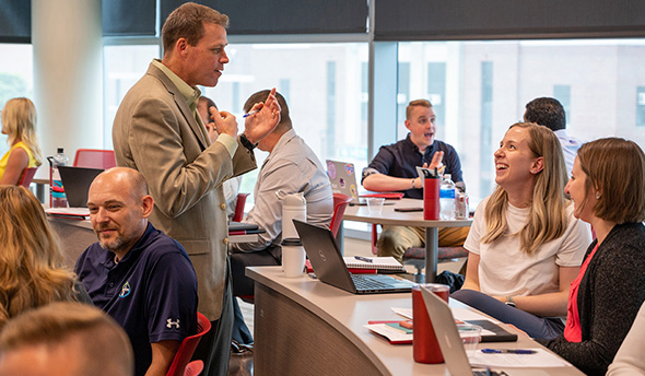 Online MBA students came to campus at the University of Nebraska-Lincoln to learn more about adaptive leadership. Part of a graduate course taught by Jake Messersmith (center), associate professor of management, they met with peers to create leadership plans to tackle organizational problems.