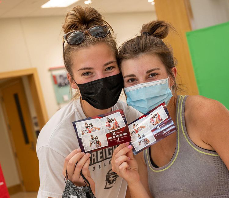 Masked students posing for group photo in workspace