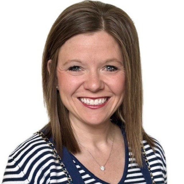 Woman with shoulder-length brown hair, wearing a striped shirt and necklace against a white background.
