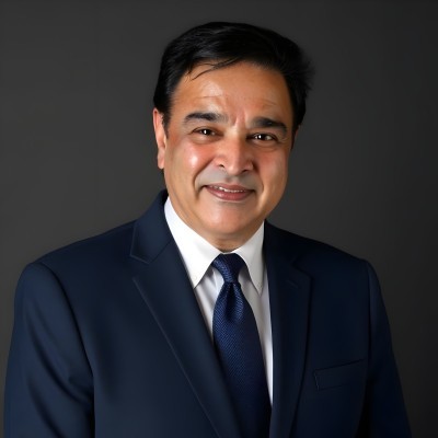 Man in a navy suit and tie against a dark gray background. Gurpreet Dhillon