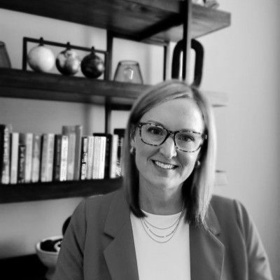 Allison Hamel; Office bookshelf with books, globes, and decorative items in a black-and-white setting.