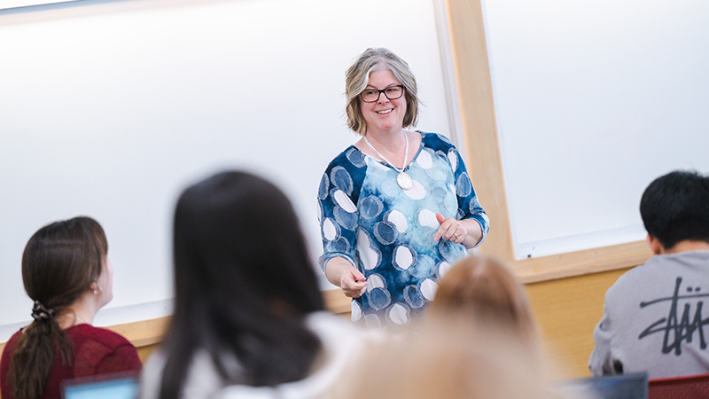 Teacher speaking to students in a classroom setting.