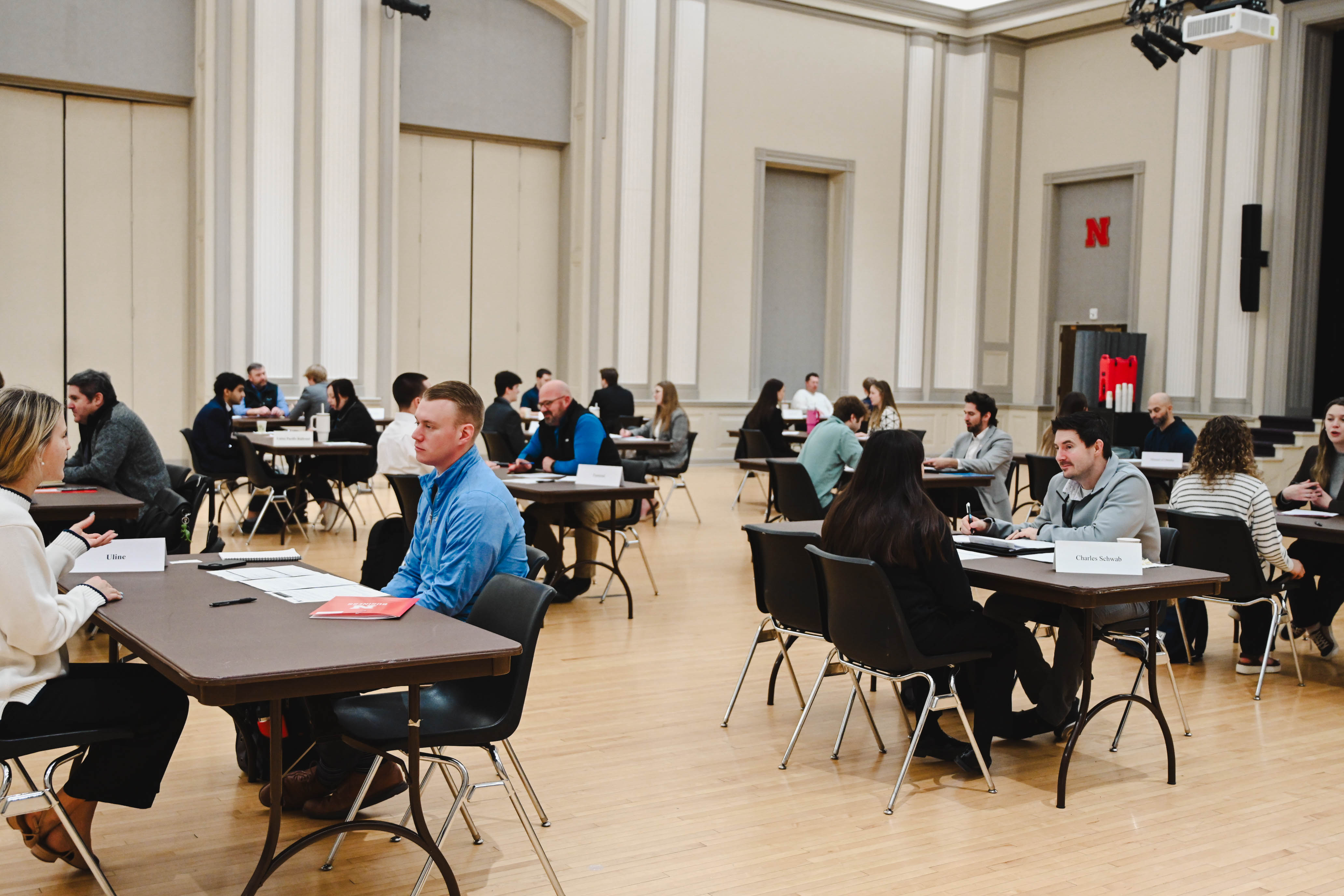People seated at tables in a large room, engaged in discussions.