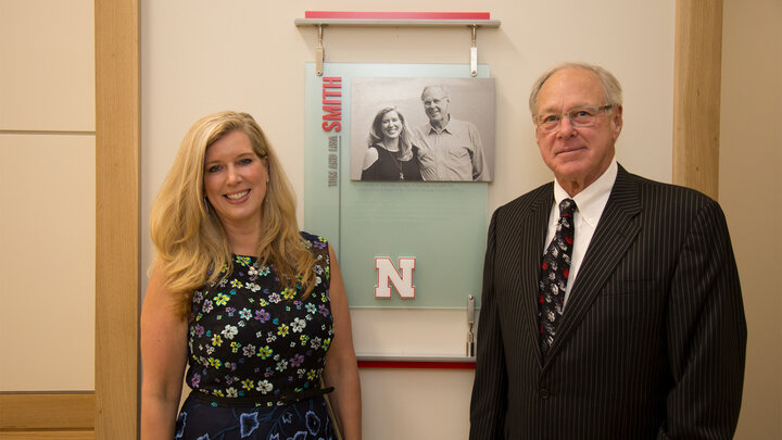 Lisa and Tom pose by their plaque in Hawks Hall