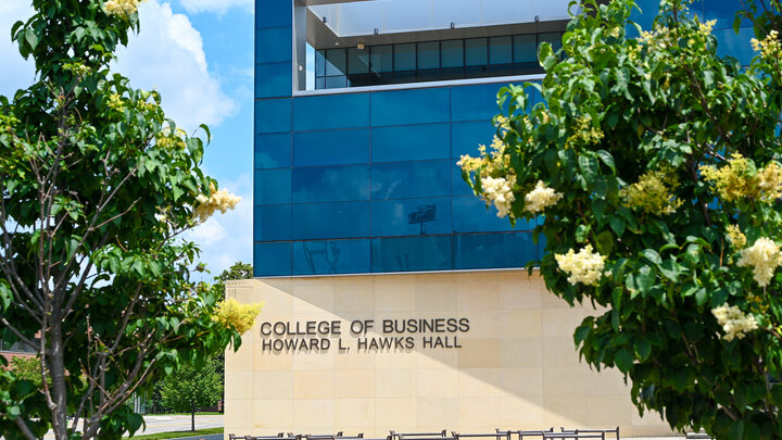 Exterior view of Hawks Hall with flowering trees in the foreground