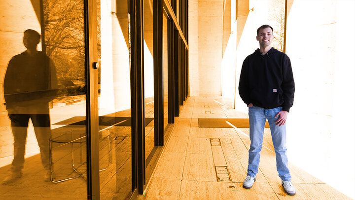 Randall stands outside the doors of the museum with an orange hue