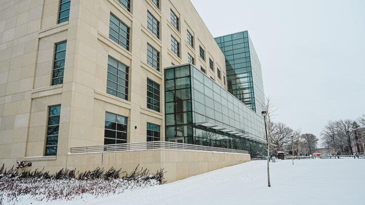 Exterior view of Hawks Hall with snow on the sidewalk