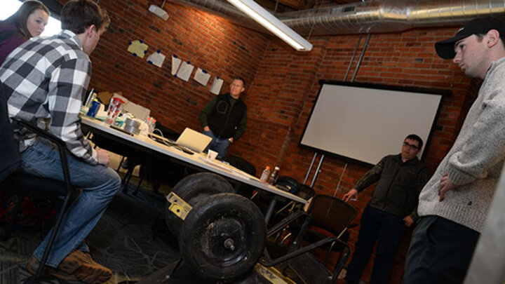 Austin Hofeling (right) meets with Lincoln Startup Mentor Chris Kalkowski (center) and the rest of the wheelbarrow business team.