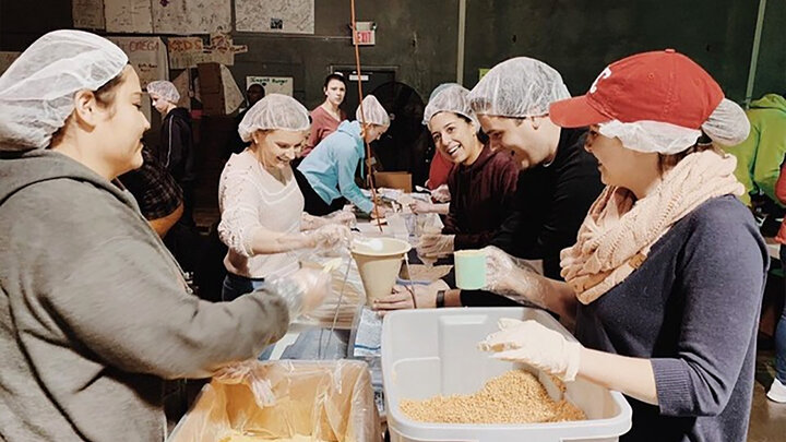 Chapter 25 service project team working together and packing meals to make a difference in the lives of those all across the world.
