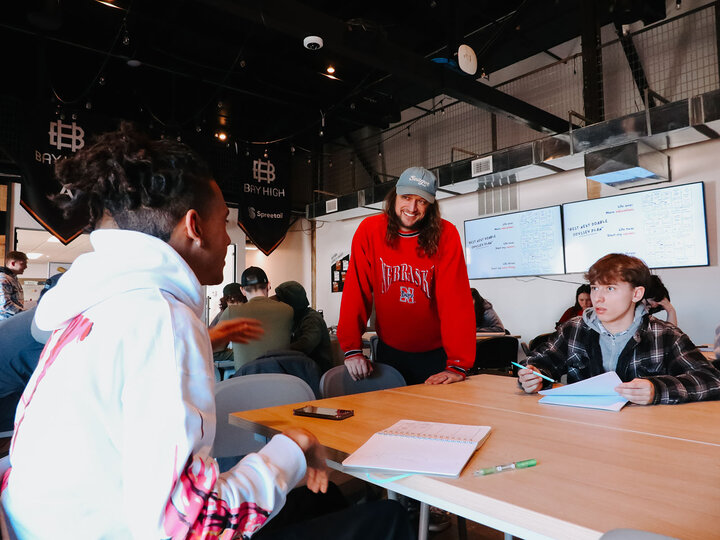 Mike Smith leans over a table talking with a student attending the workshop.