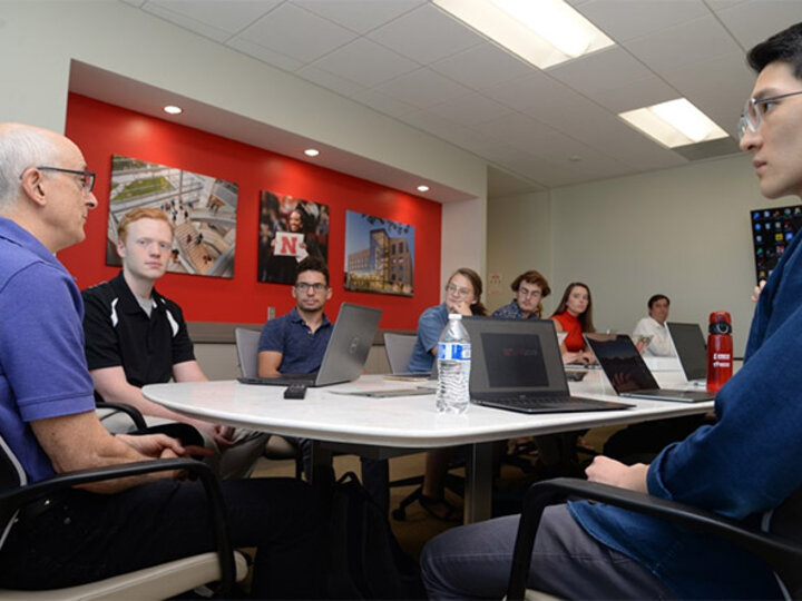 Aaron Wang (far right) listens to Dr. David Rosenbaum, professor of economics and associate professor of the Bureau of Business Research, explain research objectives to fellow Bureau of Business Research Scholars.