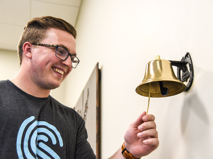 Hunter Kelley, ’19, rings the 'Success Bell' indicating a job offer from Spreetail.