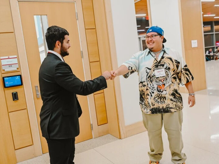 two men shaking hands in hawks hall