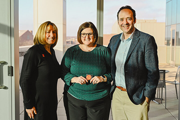 Amanda holds a Dean's Coin with Dean Farrell and Sam Nelson