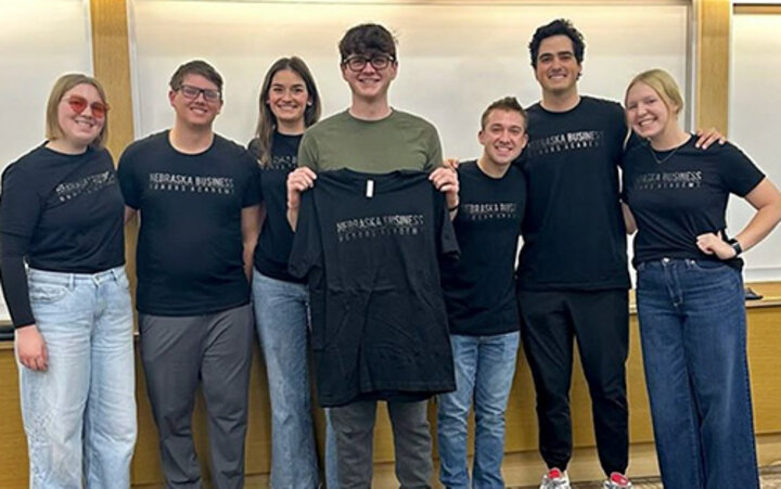 Students hold up black shirts that say Honors Academy