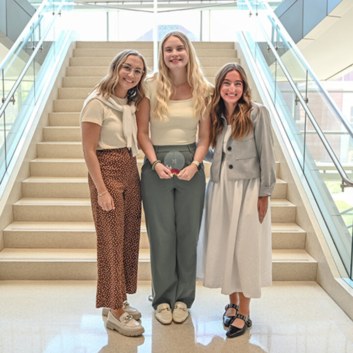 Student stands with her award and two Lutz employees who nominated her