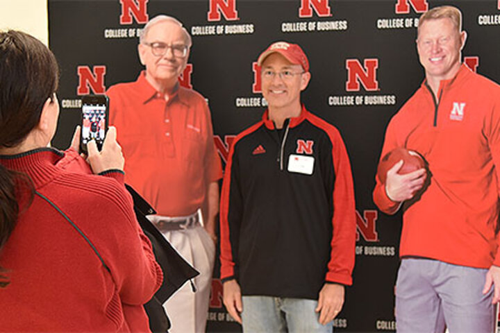 Tailgate attendees posed with fellow alums Warren Buffett and Scott Frost.