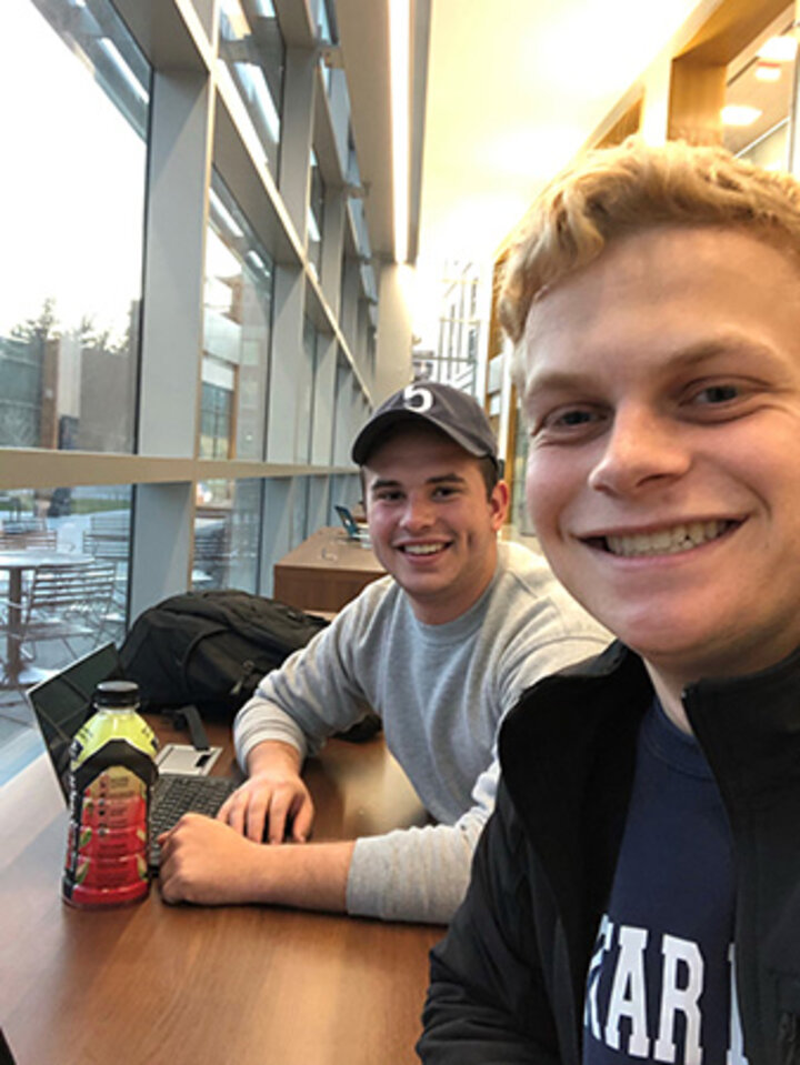 Chase Caverzagie works with Tyler Jacobson on their business plan for Benin in Hawks Hall.