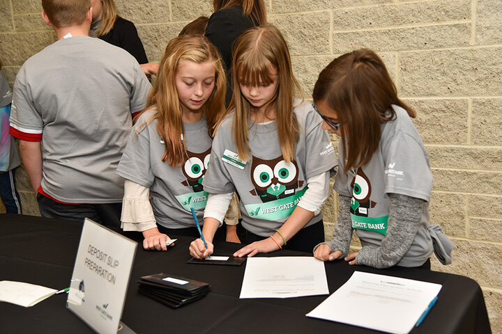Children writing a bank deposit