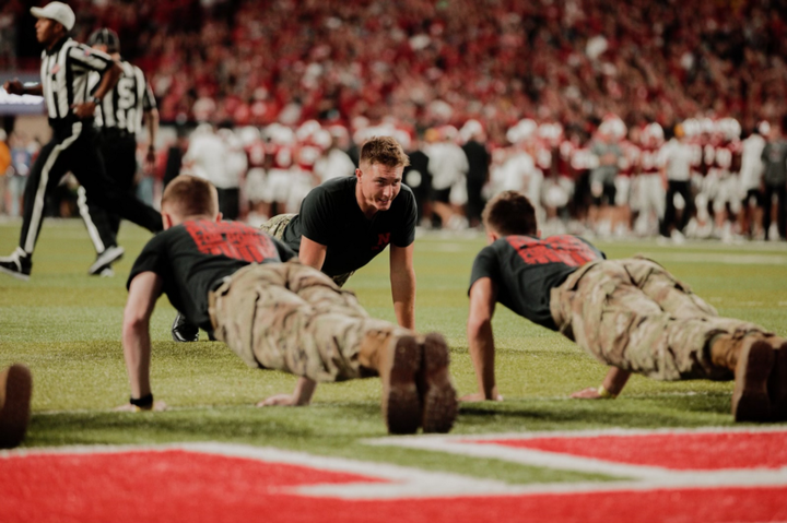 Cohan Bonow does pushups during a Husker football home game. 