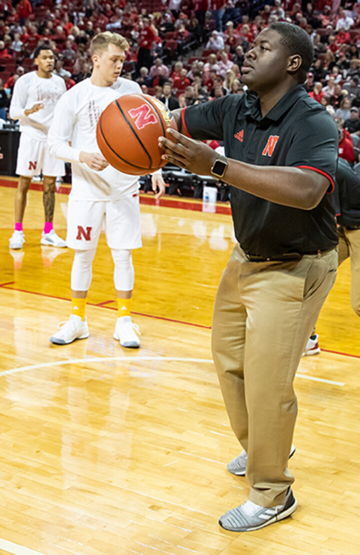 Ulysses Johnson assists the Husker Men’s Basketball team during warmups at the Ohio State game last year. He continues to serve as student manager this season.